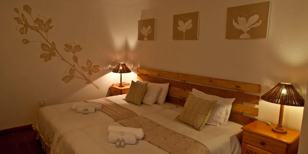 Cozy bedroom with two beds wooden headboard and warm lighting