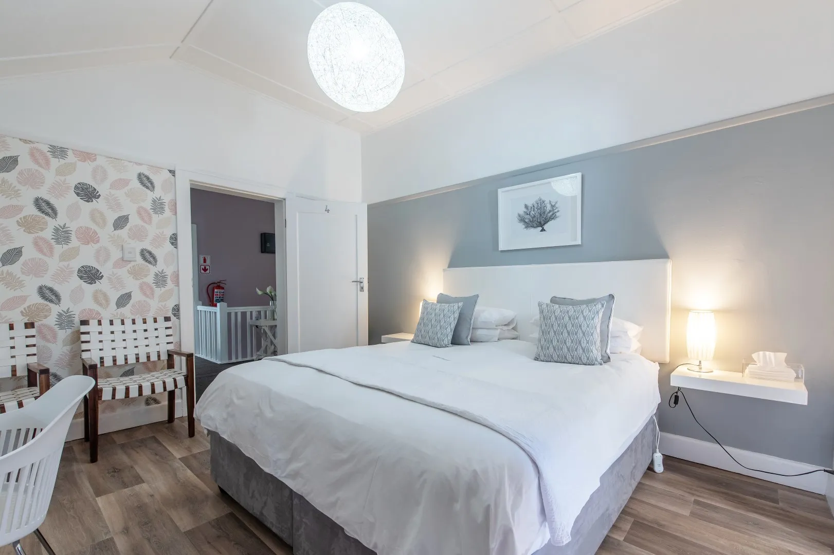 Modern bedroom with large bed pillows and a hanging light fixture
