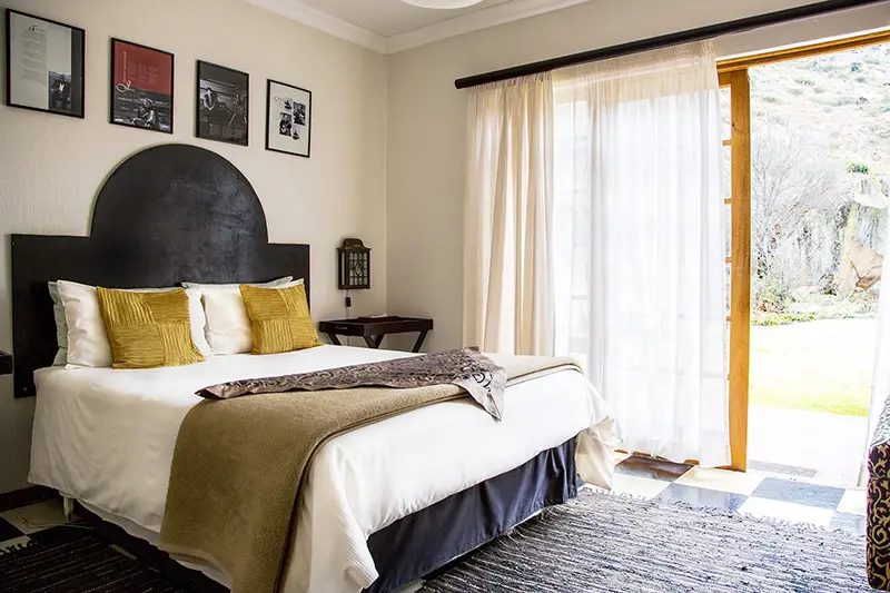 Cozy bedroom with a large bed open sliding door to a garden view