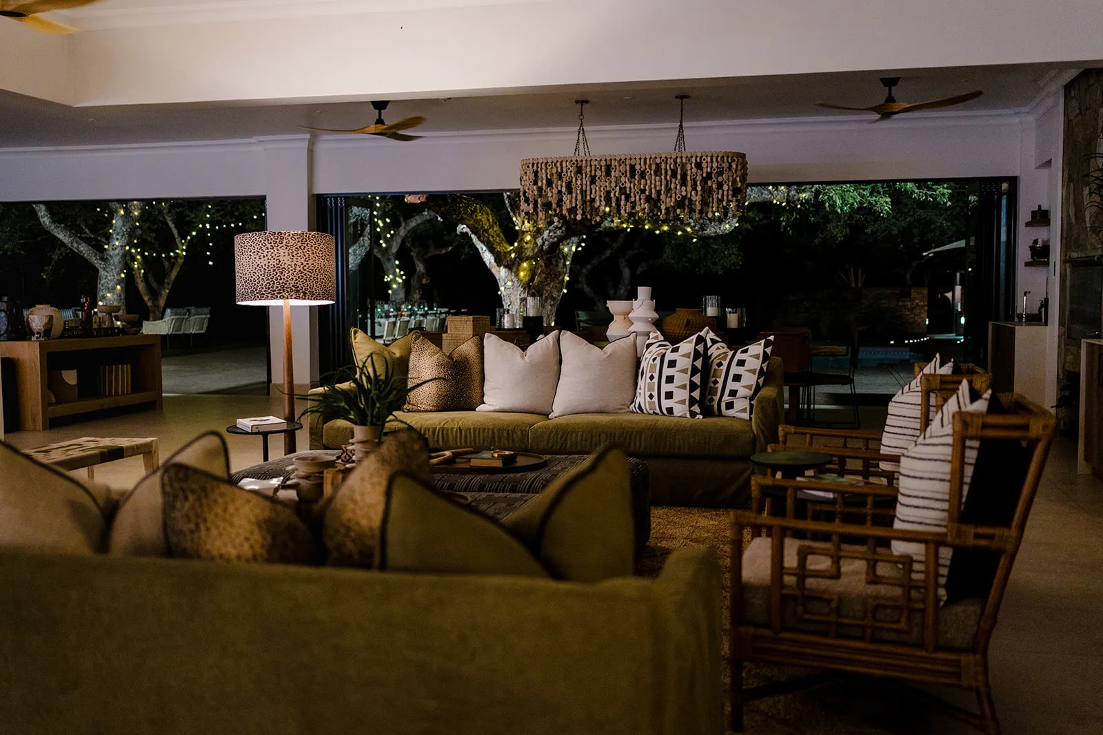 Cozy living room with green sofas pillows and outdoor view at night