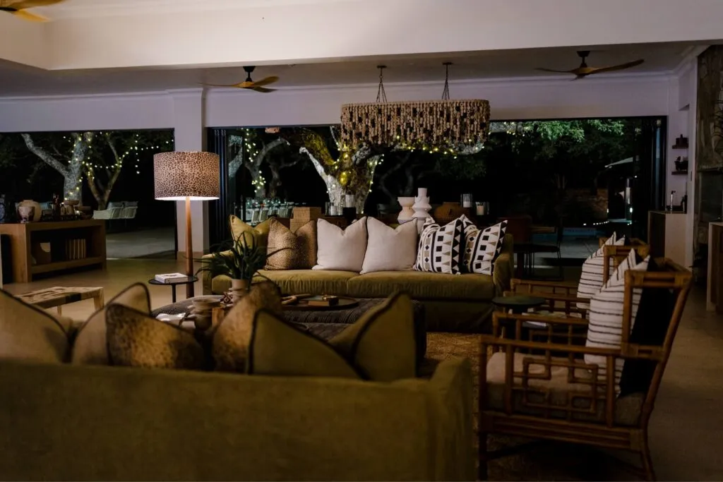 Cozy living room with green sofas pillows and outdoor view at night