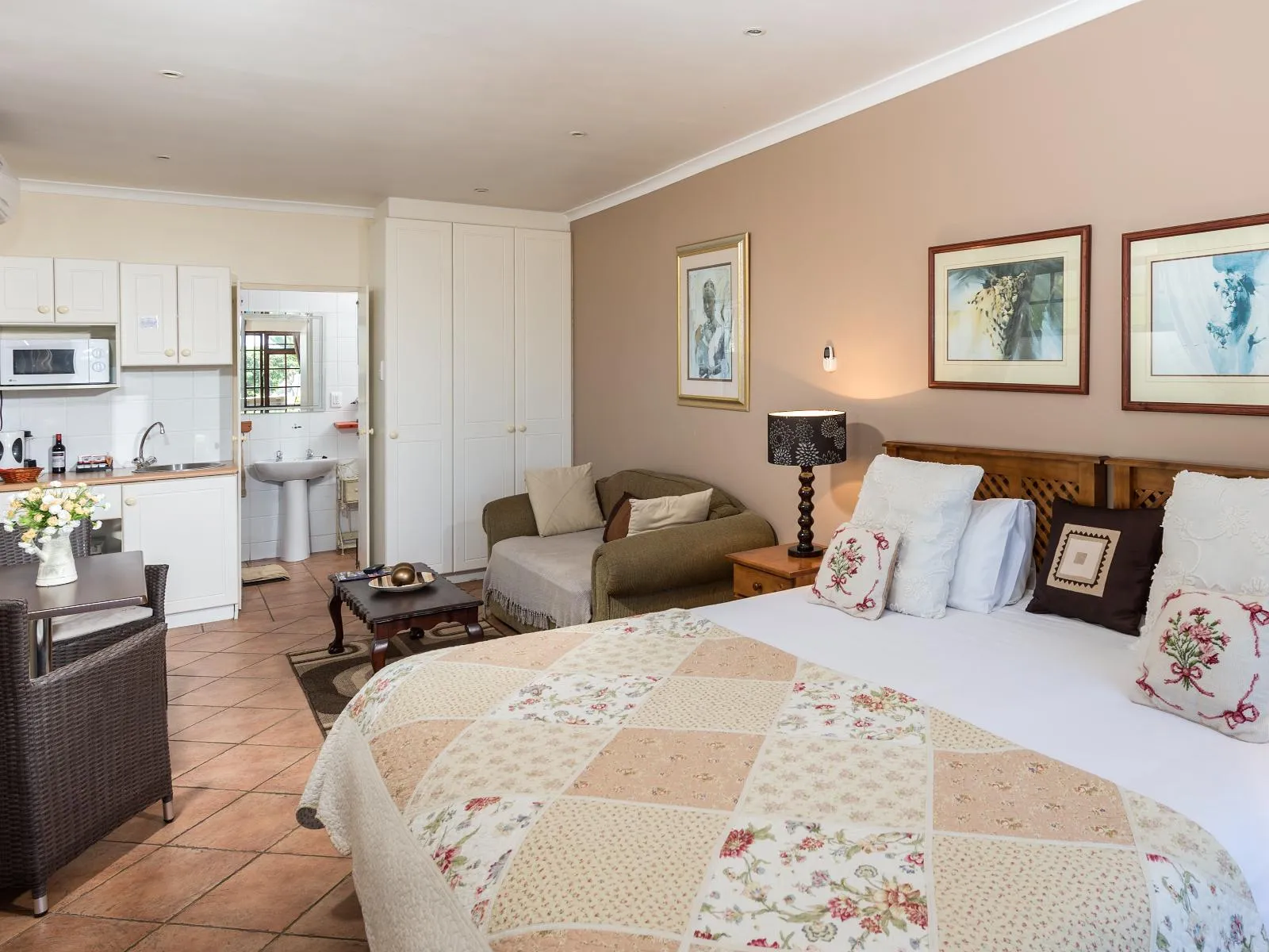 Cozy bedroom with a kitchenette and seating area in a small apartment