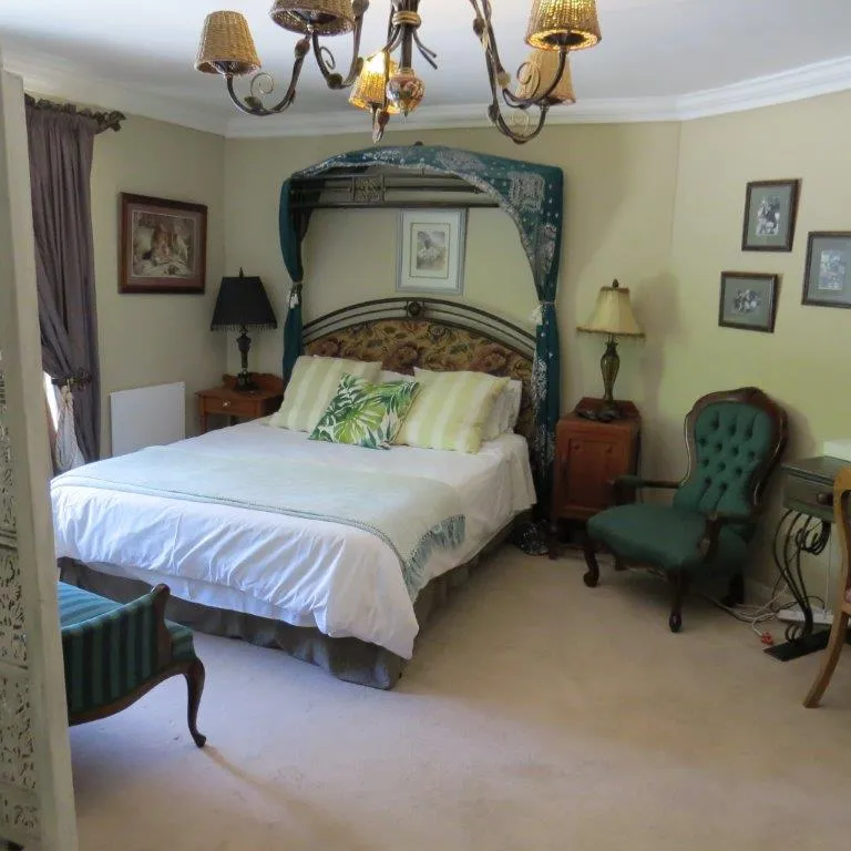 Cozy bedroom with a large bed green armchair and vintage decor