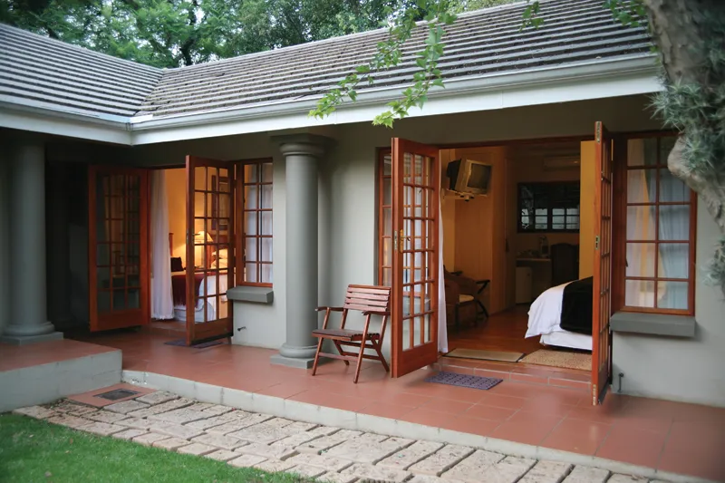 Cozy house with open wooden doors tiled patio and garden pathway