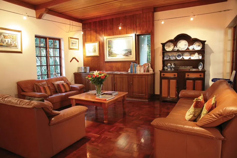 Cozy living room with wooden furniture leather sofas and a floral centerpiece