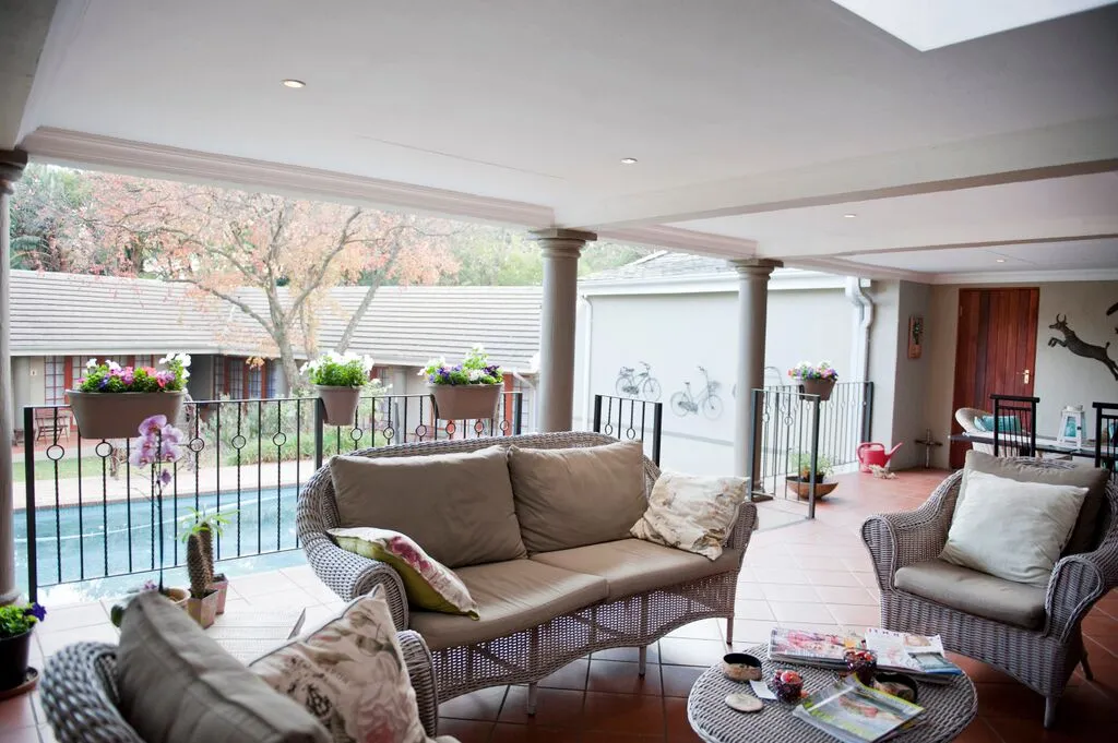 Outdoor patio with wicker furniture pool and garden view