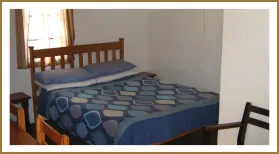 Bedroom with a neatly made bed and wooden furniture
