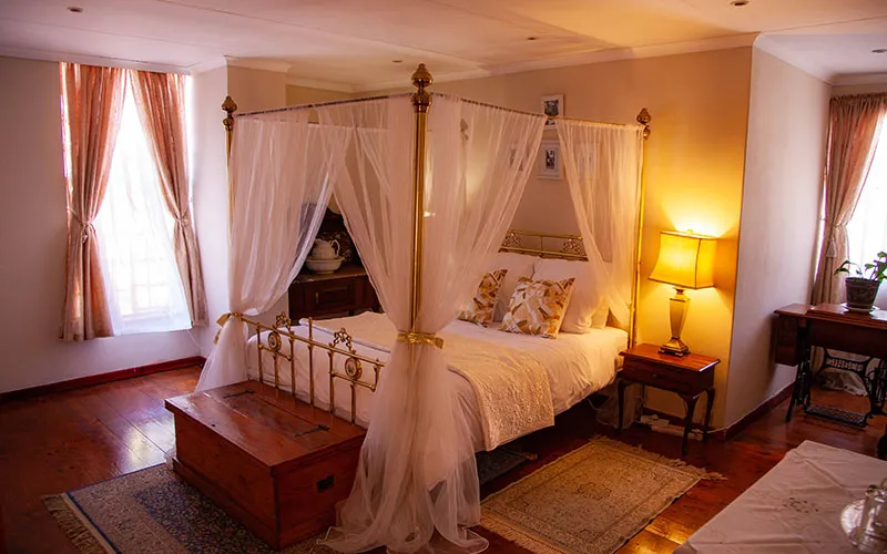 Cozy bedroom with a fourposter bed warm lighting and wooden flooring