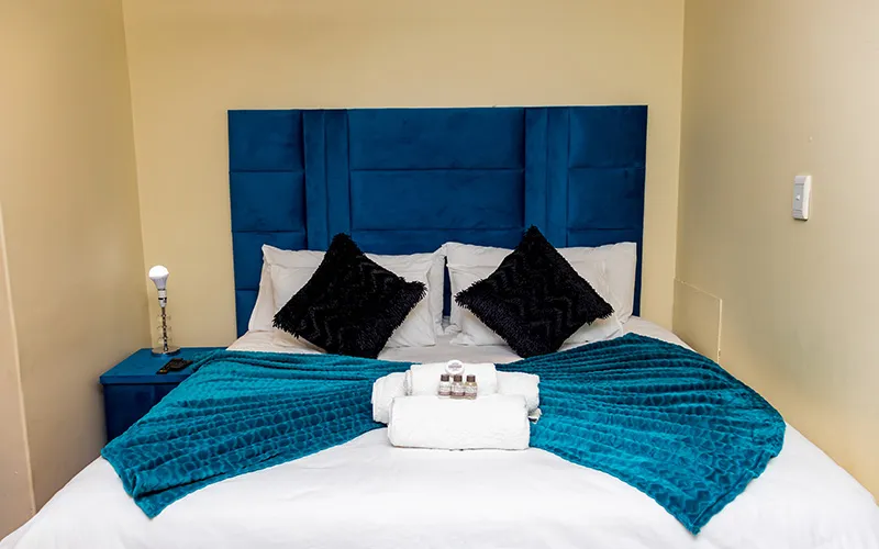 Cozy bedroom with a neatly made bed and bedside lamp