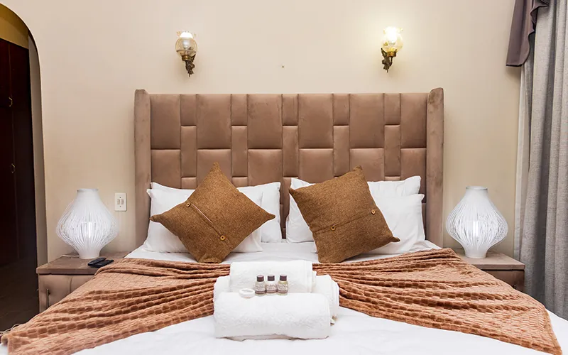 Cozy bedroom with a large bed pillows and decorative lamps on nightstands