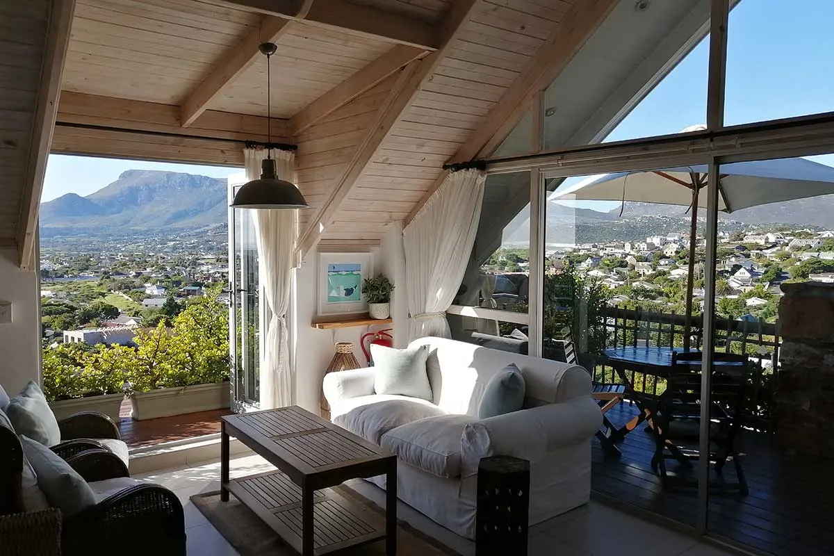 Bright living room with large windows overlooking a city and mountains