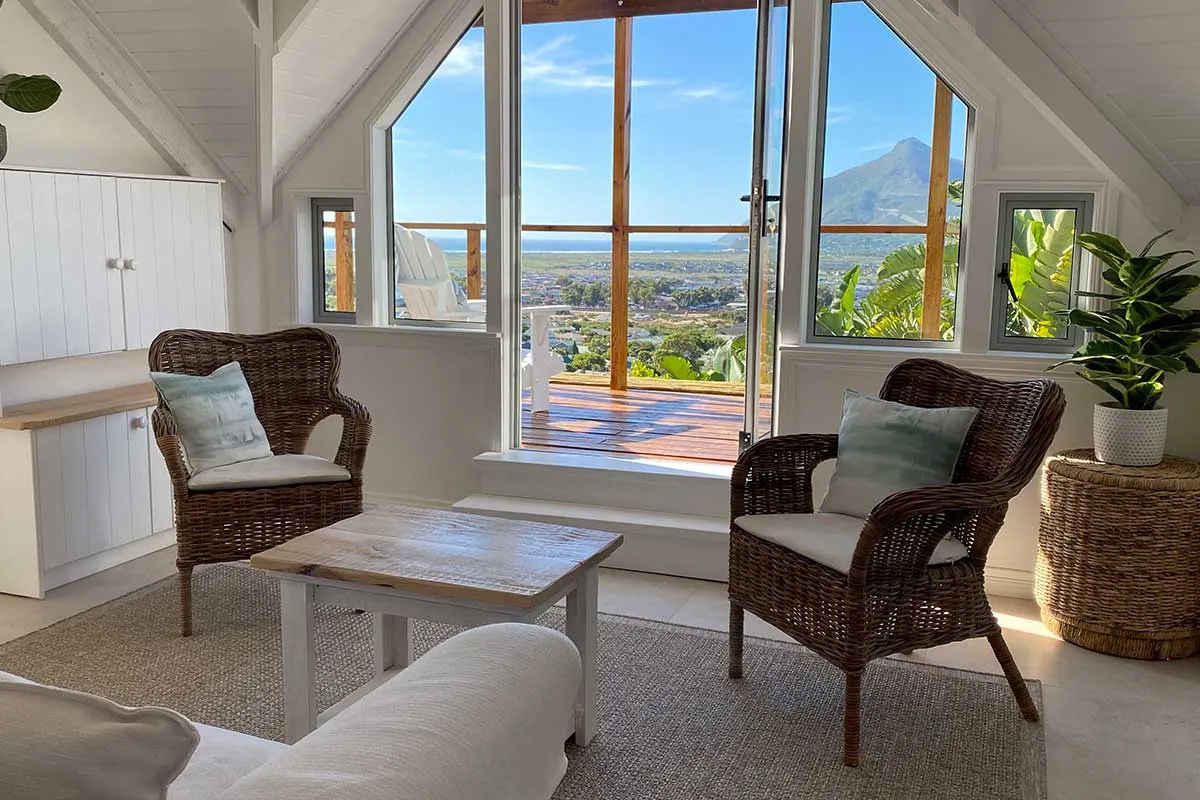 Two wicker chairs in a bright living room with a scenic view