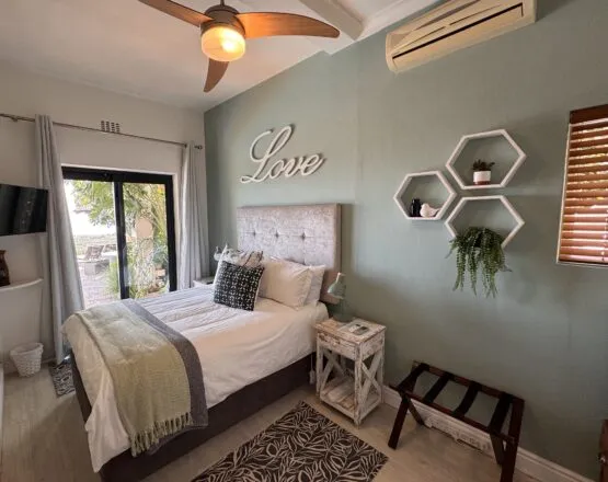 Cozy bedroom with a bed ceiling fan and wall decor reading Love