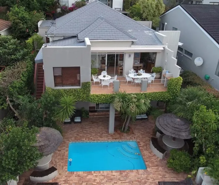 Modern house with rooftop deck pool and lush greenery in a suburban setting