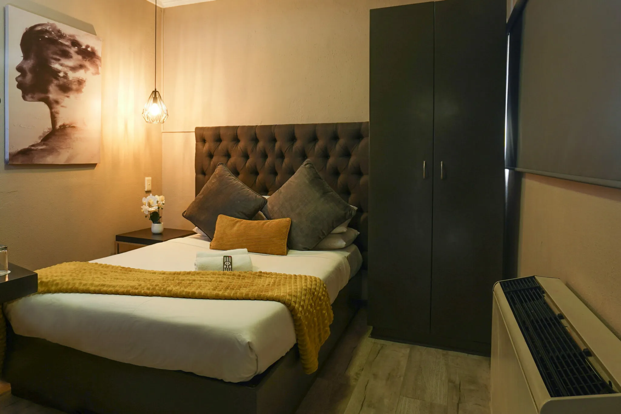 Modern bedroom with a bed artwork lamp and wardrobe