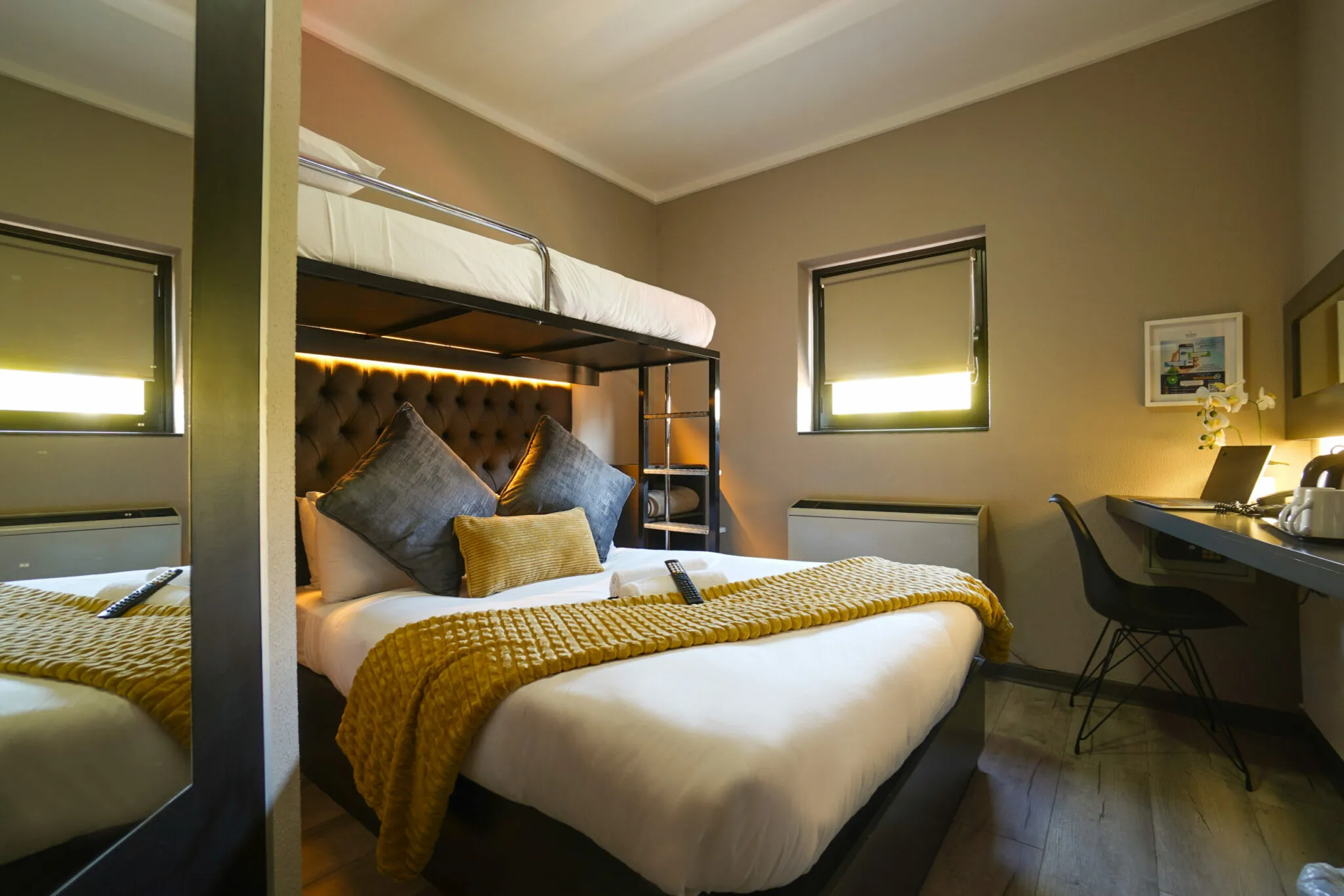 Modern hotel room with bunk bed desk and chair