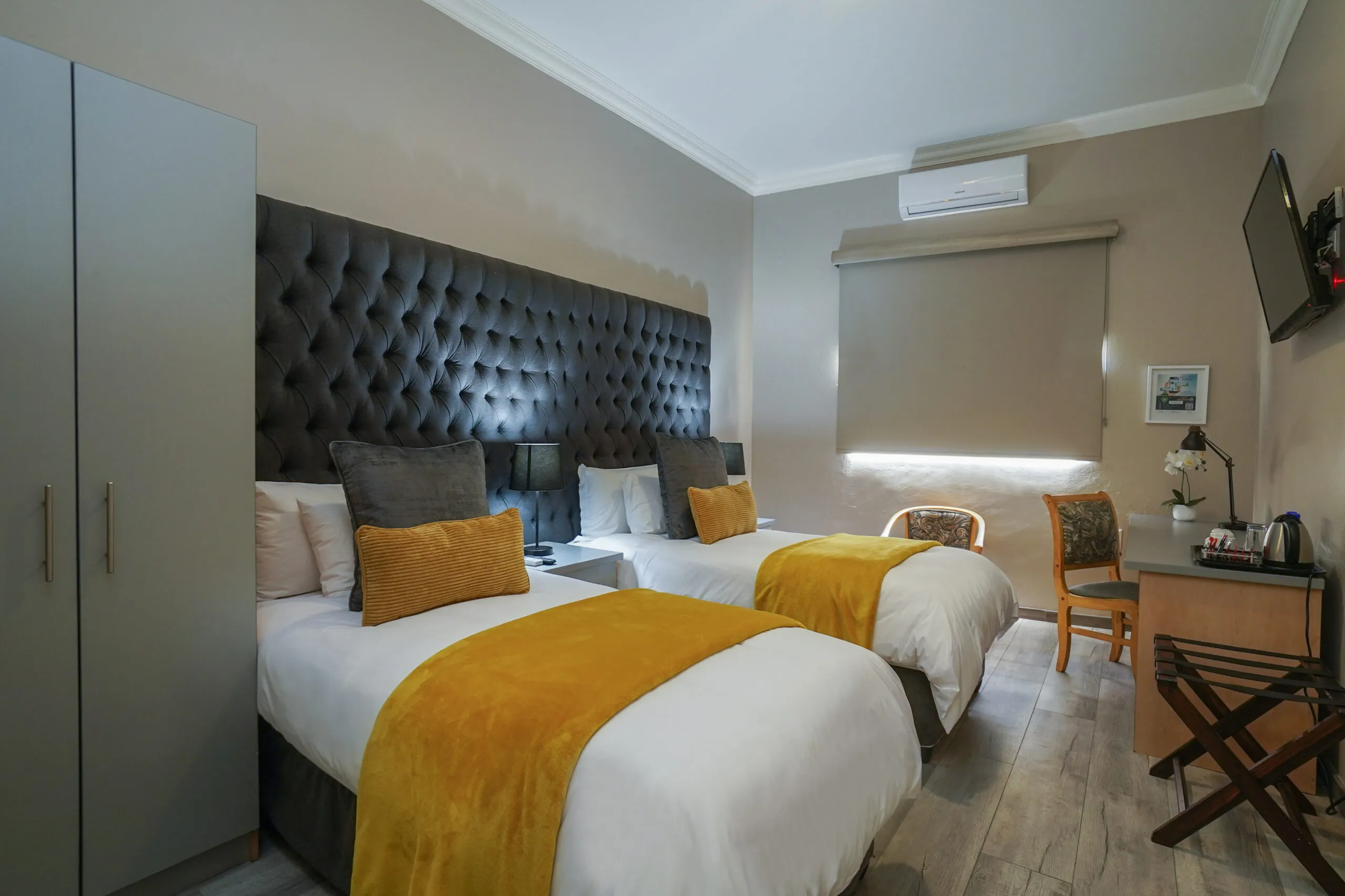 Twin beds with yellow and white bedding in a modern hotel room