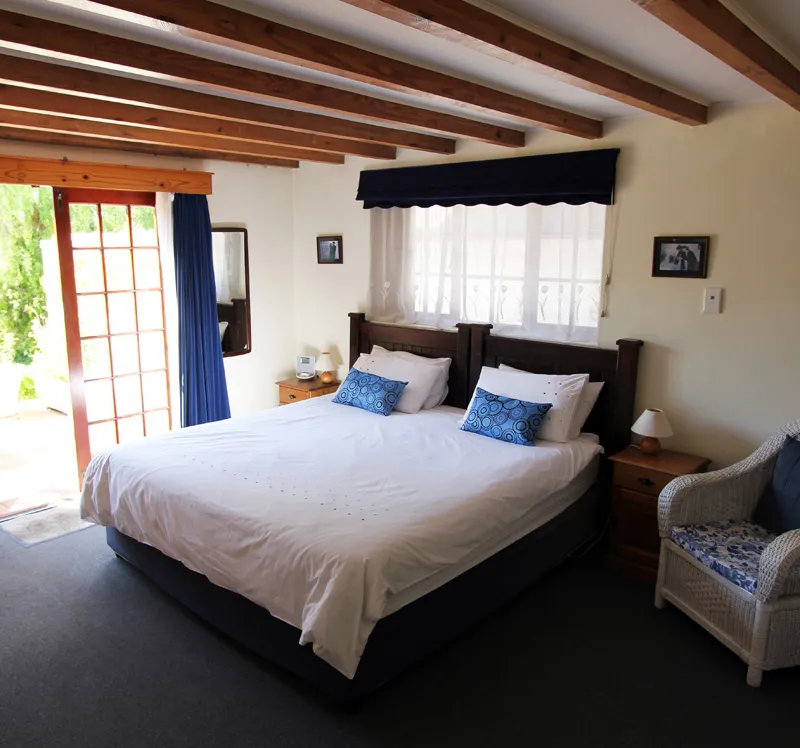 Bedroom with a large bed wooden ceiling and blue and white decor