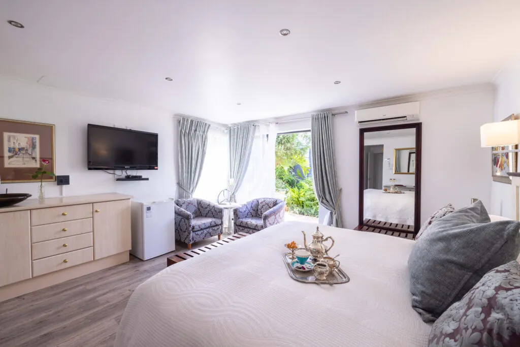 Modern bedroom with a bed TV seating area and large windows