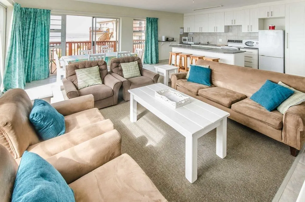 Spacious living room with beige sofas blue cushions and a white coffee table