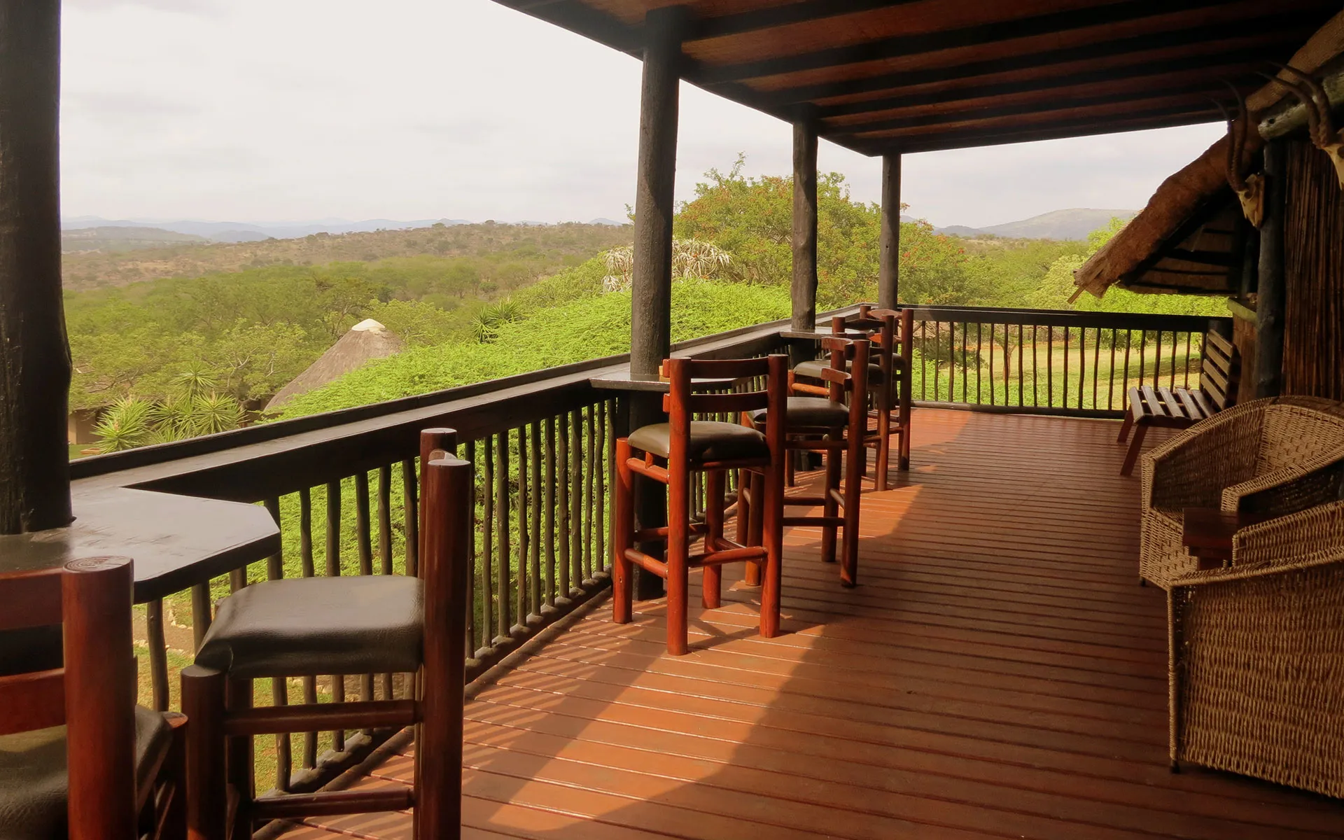Wooden deck with chairs overlooking a scenic landscape with trees and hills