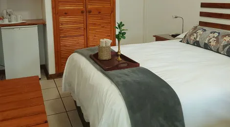 Neatly made bed with a tray of toiletries in a cozy bedroom