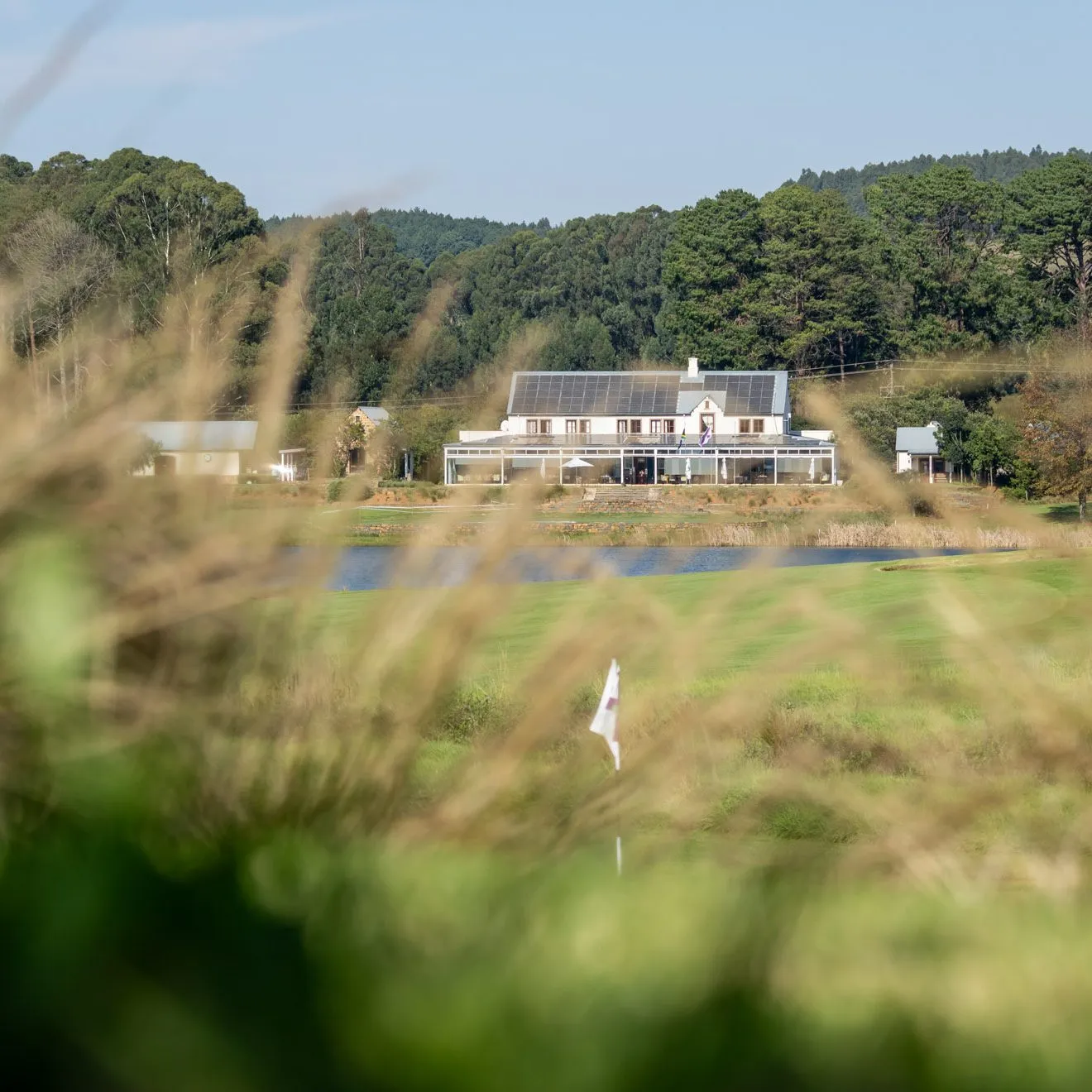 Golf course with a clubhouse and trees in the background