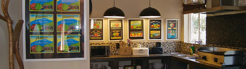 Kitchen with colorful framed artwork on the wall and various appliances on countertops