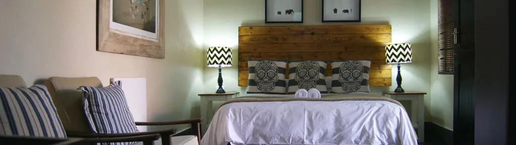 Cozy bedroom with a large bed two bedside tables and striped lamps