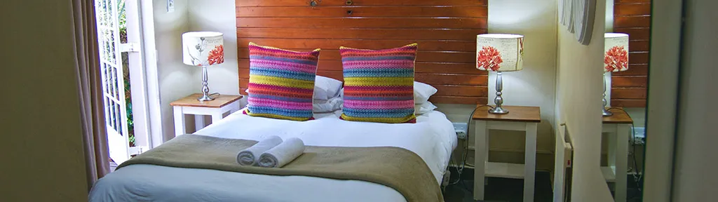 Cozy bedroom with a neatly made bed colorful pillows and bedside lamps