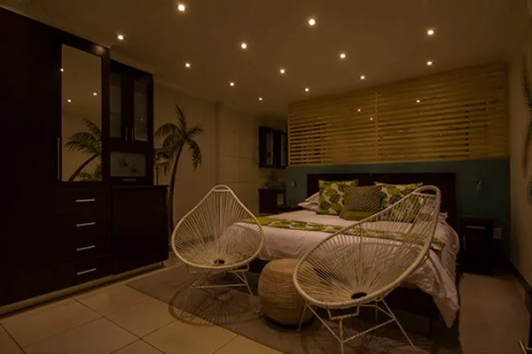 Cozy bedroom with two wicker chairs wooden furniture and warm lighting