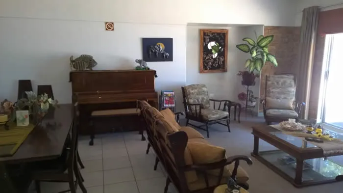 Living room with piano seating area dining table and potted plant