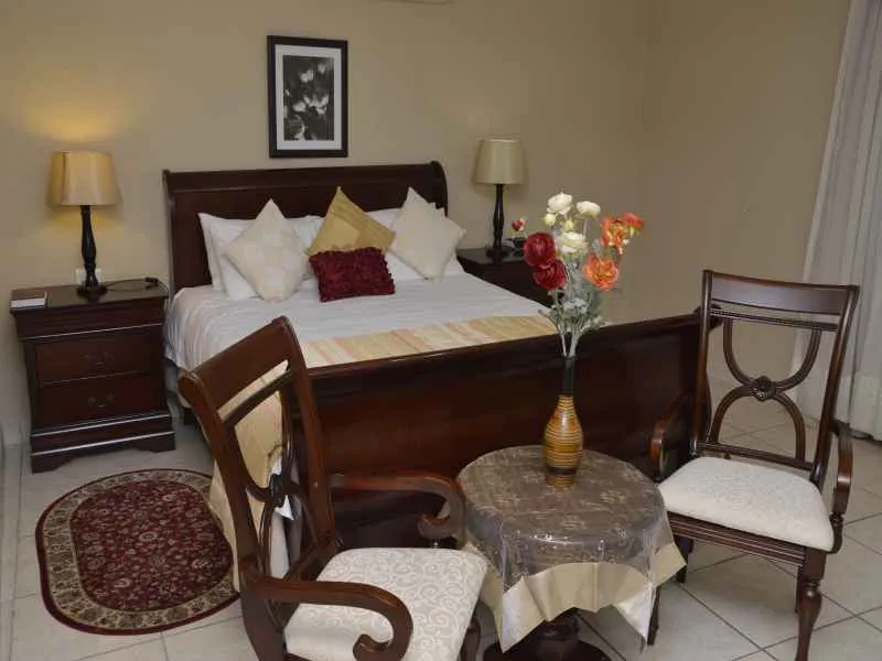 Wooden bedroom set with bed chairs table and floral arrangement