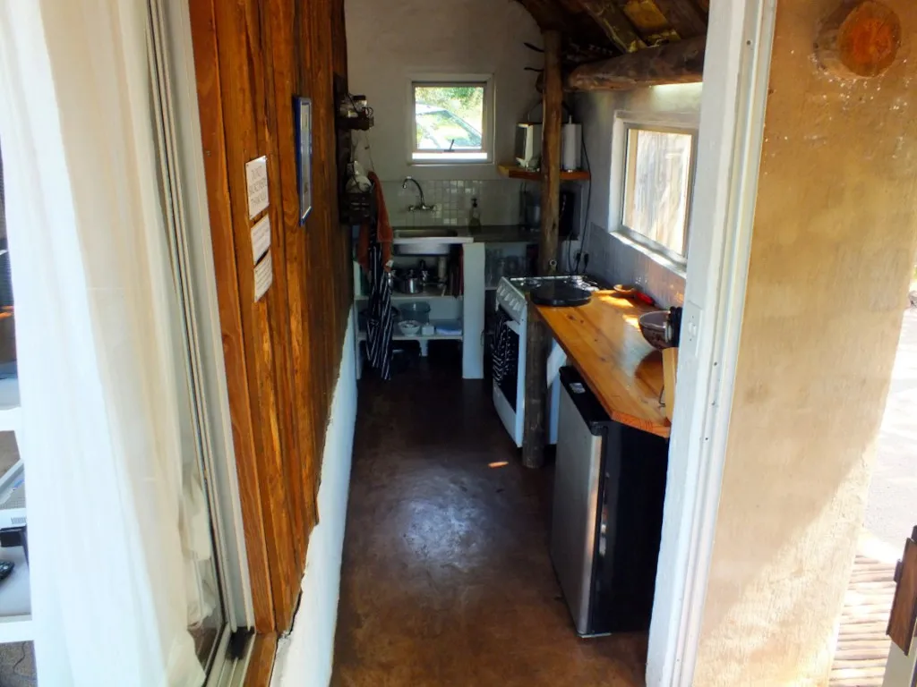 Wooden kitchen with sink stove and refrigerator in a small rustic room
