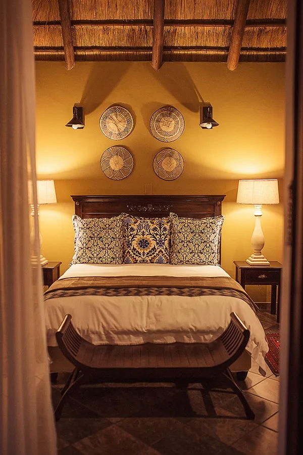 Cozy bedroom with a large bed decorative pillows and woven wall hangings