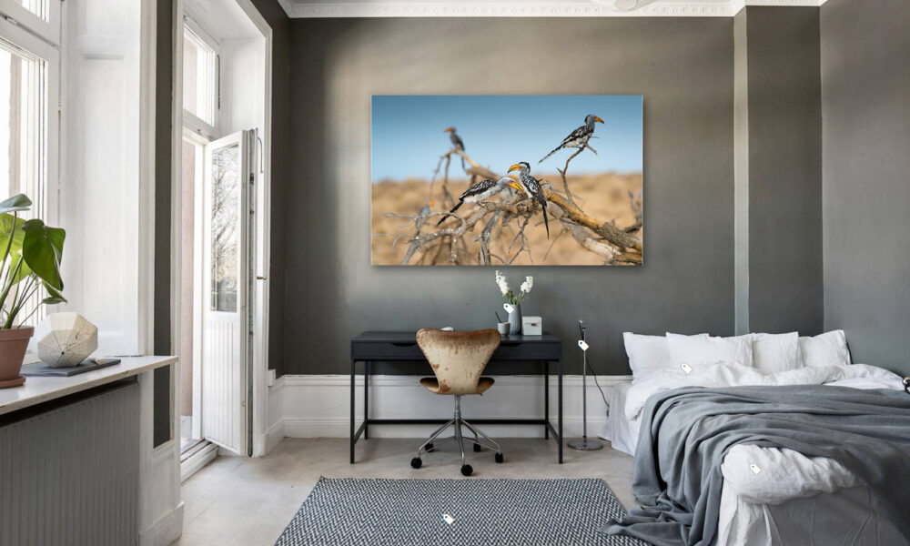 Modern bedroom with large bird artwork on the wall and a desk.