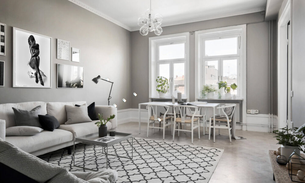 Modern living room with grey walls, white furniture, and large windows.