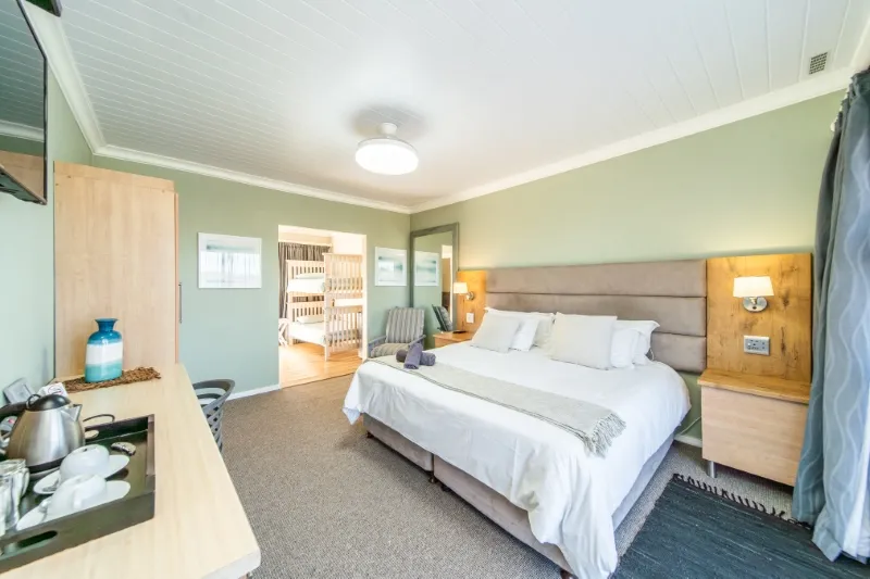 Bedroom with large bed wooden furniture and a kitchenette area