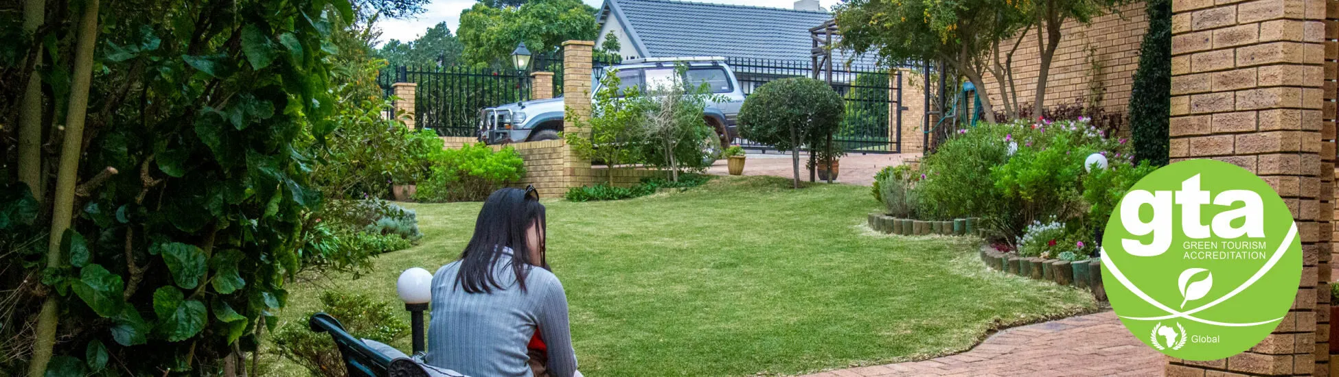 Woman sitting in a garden with a house in the background GTA logo visible