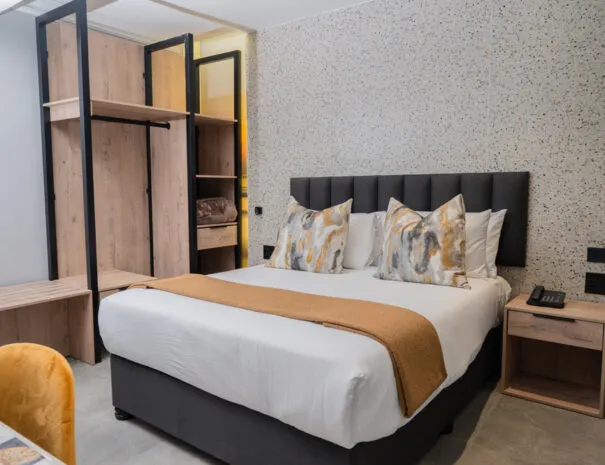 Modern bedroom with a large bed wooden furniture and patterned wallpaper