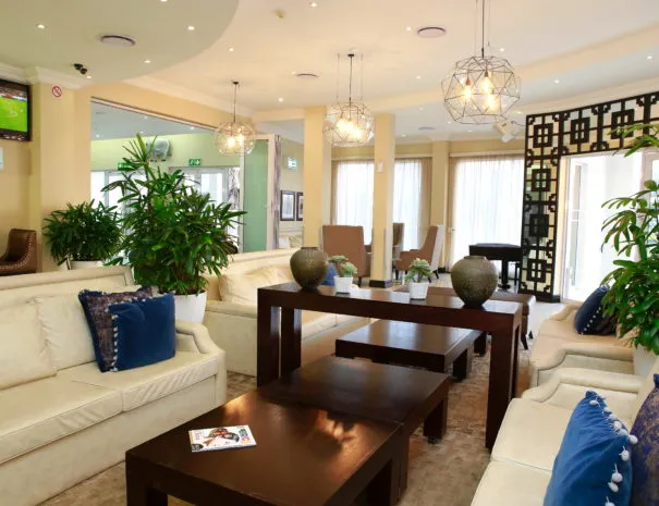 Modern lounge with sofas plants and decorative lights in a bright room