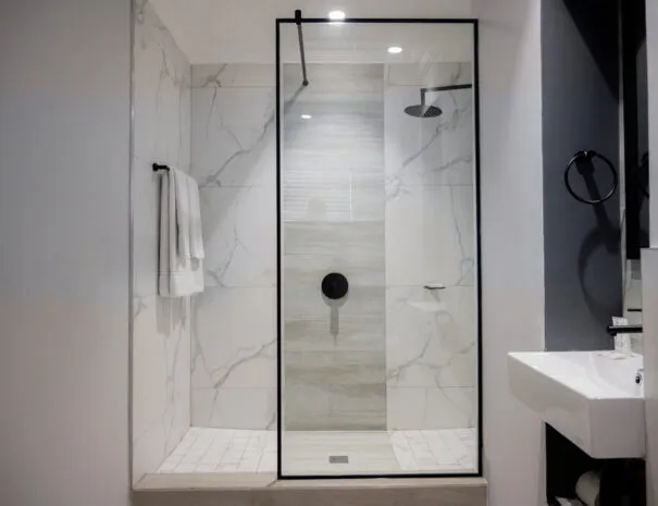 Modern bathroom with a glass shower enclosure and marble walls
