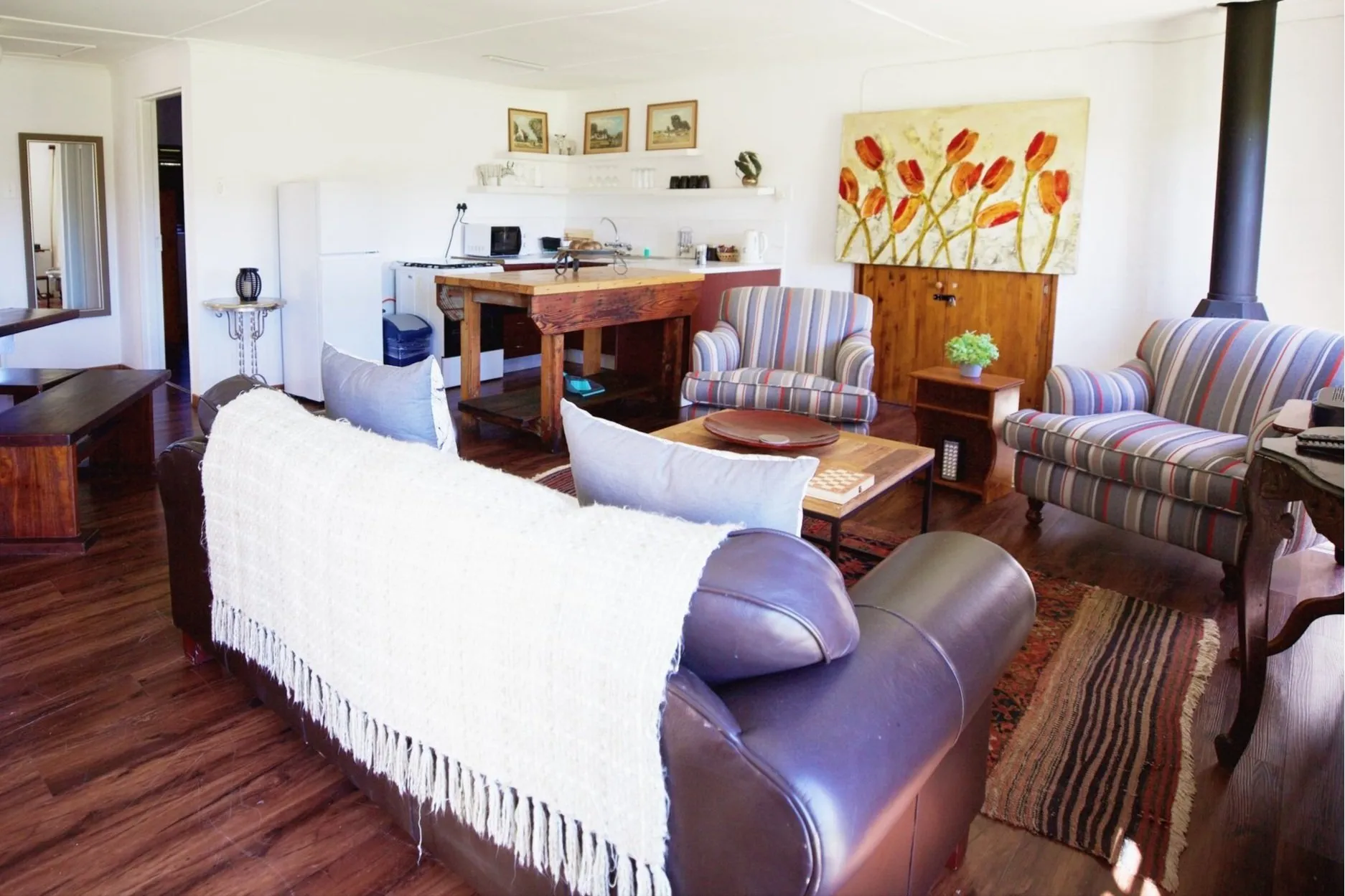 Cozy living room with mixed furniture colorful painting and wooden floor