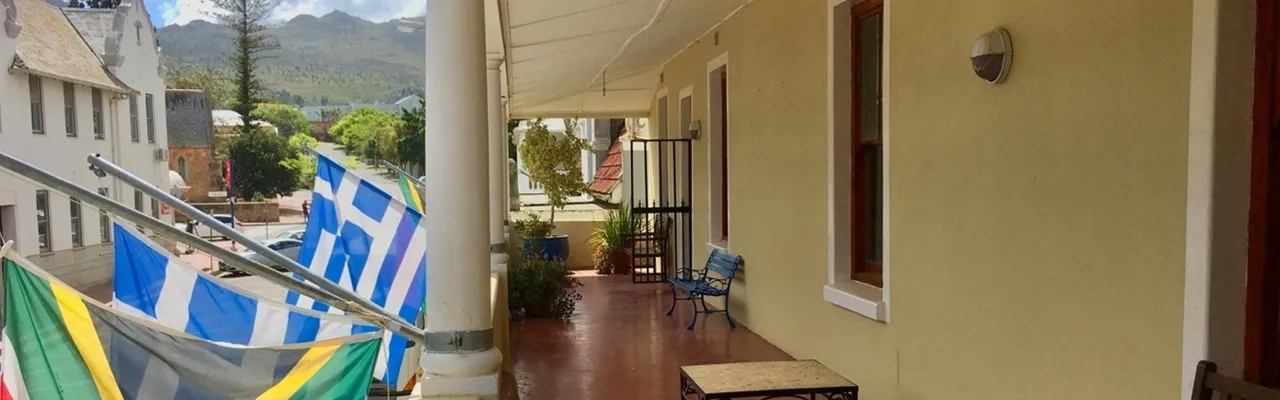 Greek and South African flags on a balcony of a building with a corridor