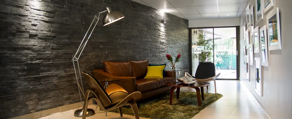 Modern lounge area with leather sofa chair and framed pictures on the wall