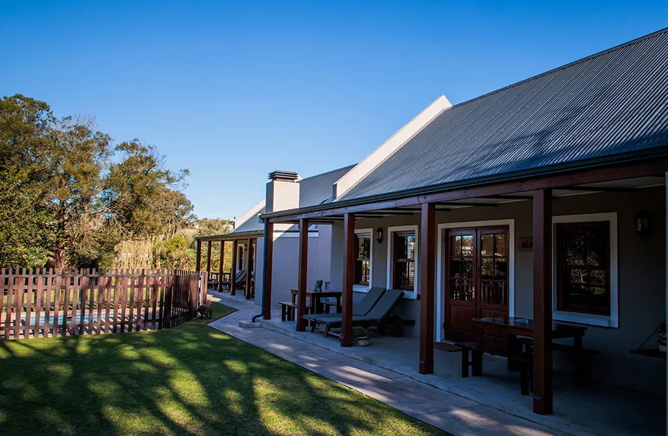 House with a veranda wooden fence and swimming pool in a sunny garden