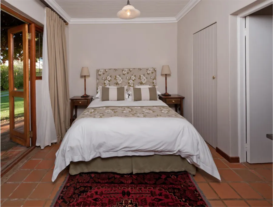 Cozy bedroom with a large bed floral headboard and tiled floor