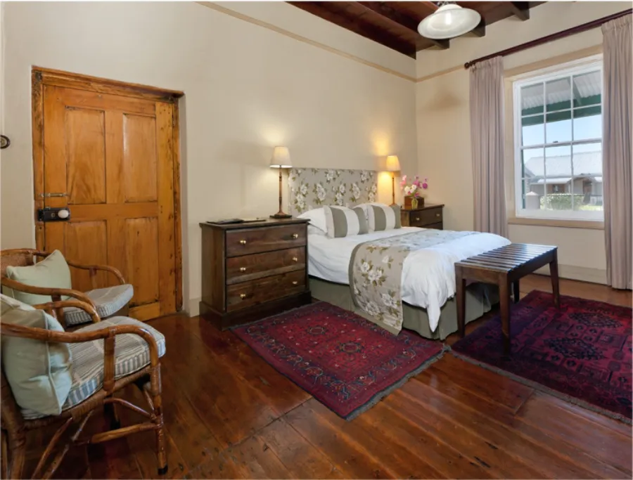 Cozy bedroom with wooden floor bed armchair and large window