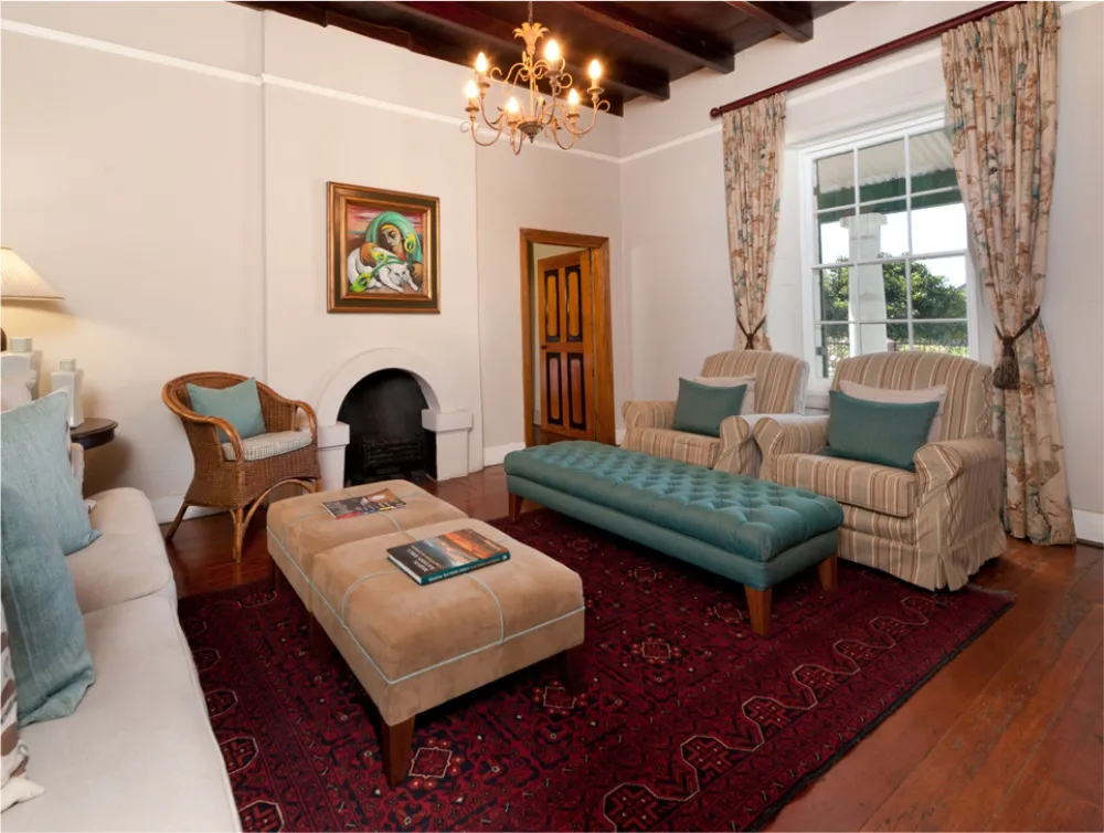 Cozy living room with fireplace armchairs sofa and patterned rug on wooden floor