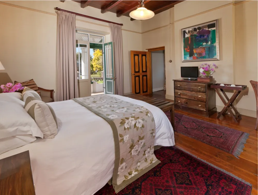 Cozy bedroom with a bed open door to balcony and wooden furniture